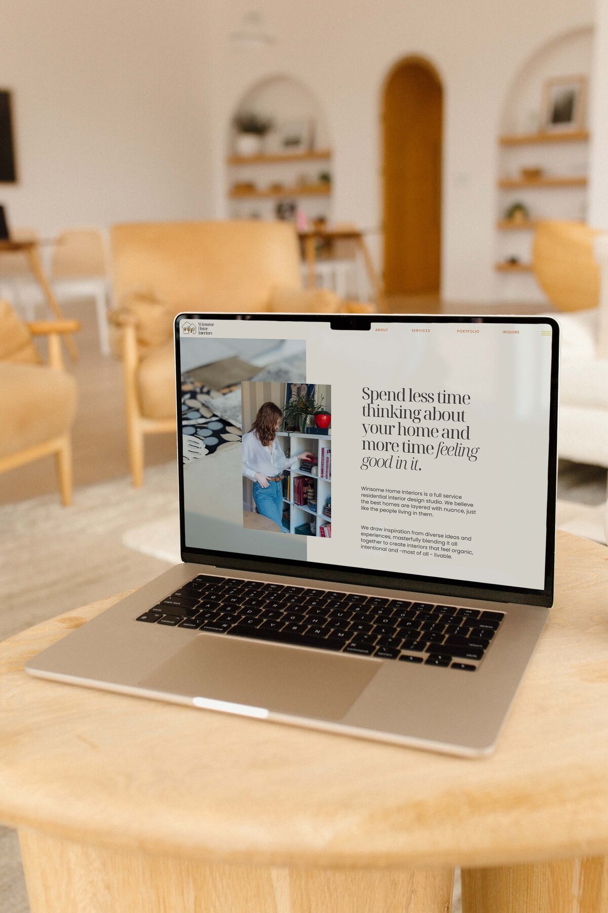 A laptop sits open to a website page representing copywriting and web design for an interior designer.