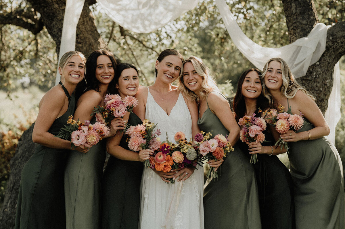 Bride and bridesmaids in green wedding dresses at Maine wedding