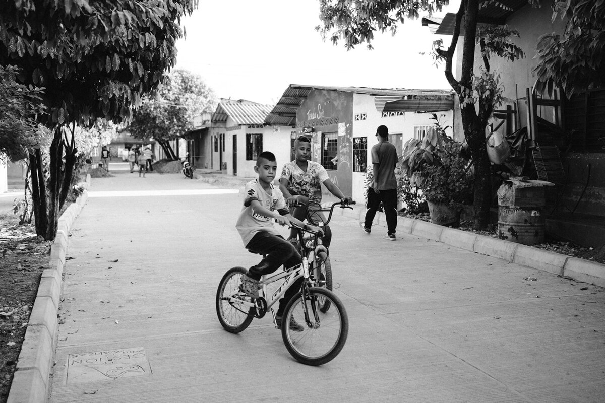 Kinderen op de fiets in een community wijk van Colombia