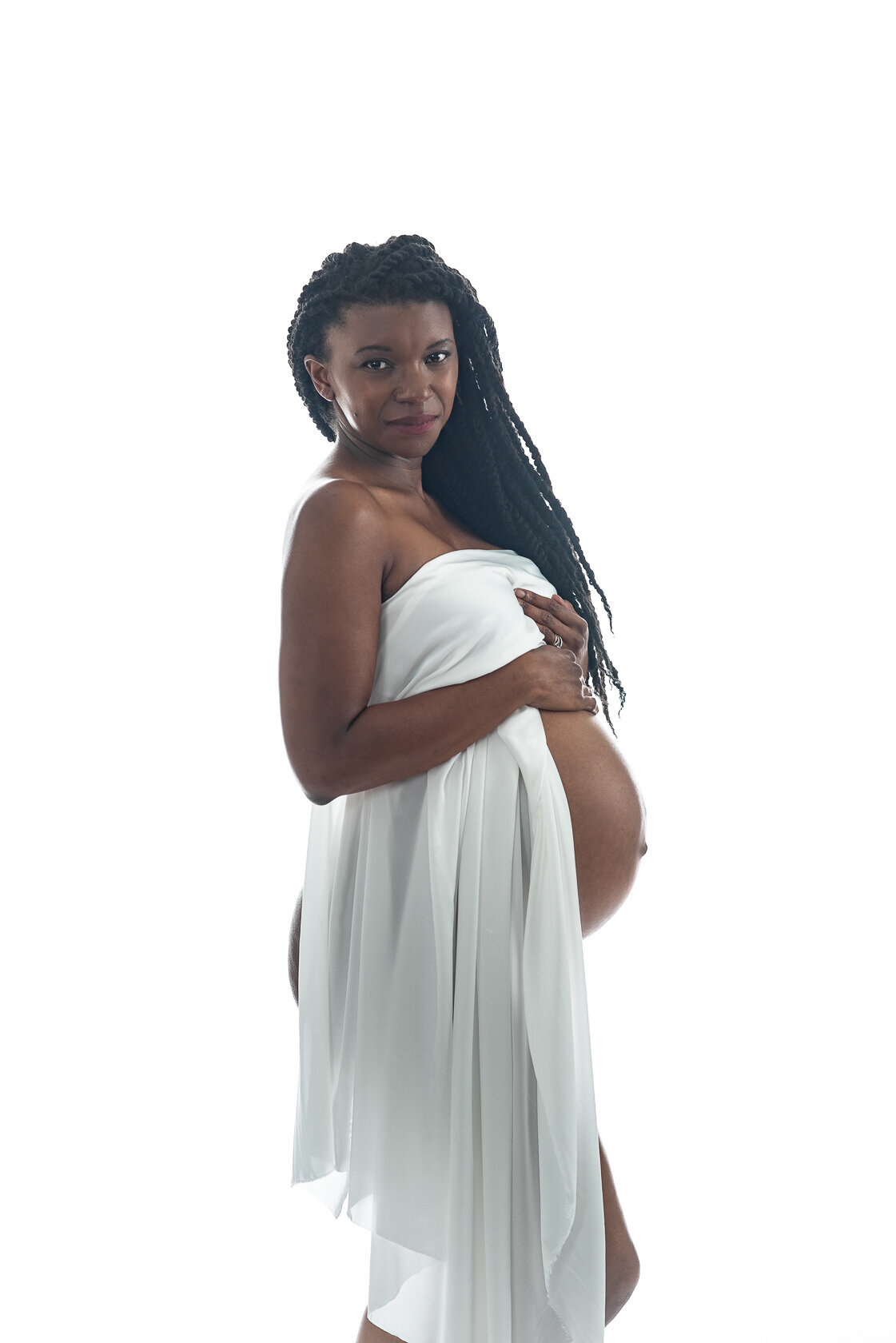 Gorgeous pregnant black woman holds up white silk . Photographed by Laura King Photography in Houston Texas.