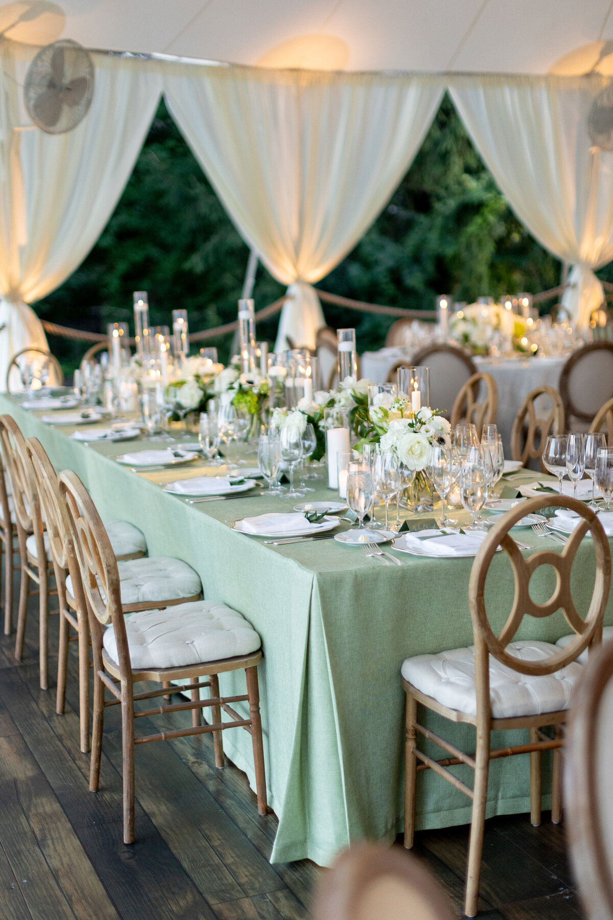 A close up of the table lined with candles and flowers. 