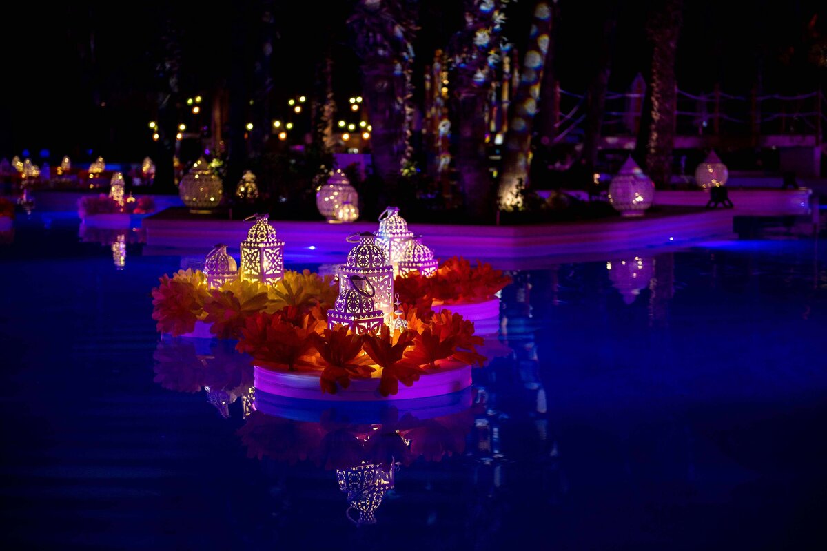 The resort pool decorated with floating lanterns at night for welcome reception celebration
