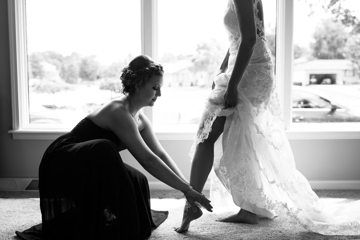 Maid of Honor helps bride put on garter