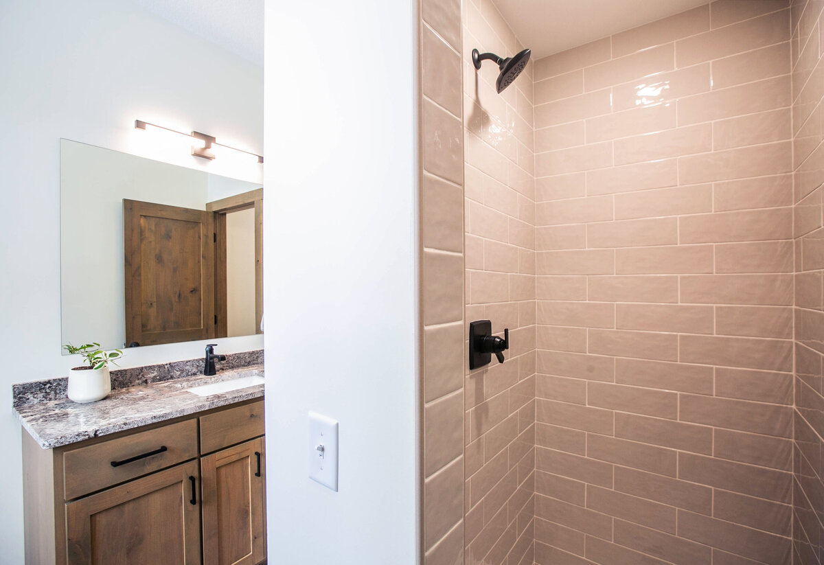 Custom bathroom with dark wood and modern accents in Elk River custom home
