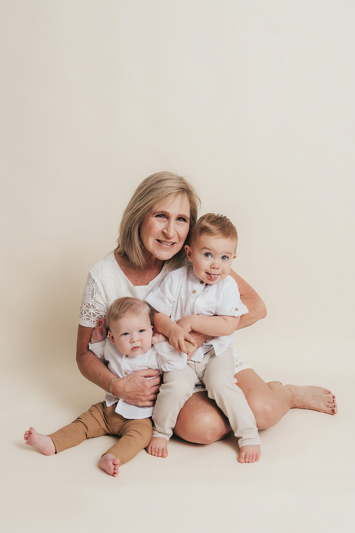 mom with two babies sitting on the ground