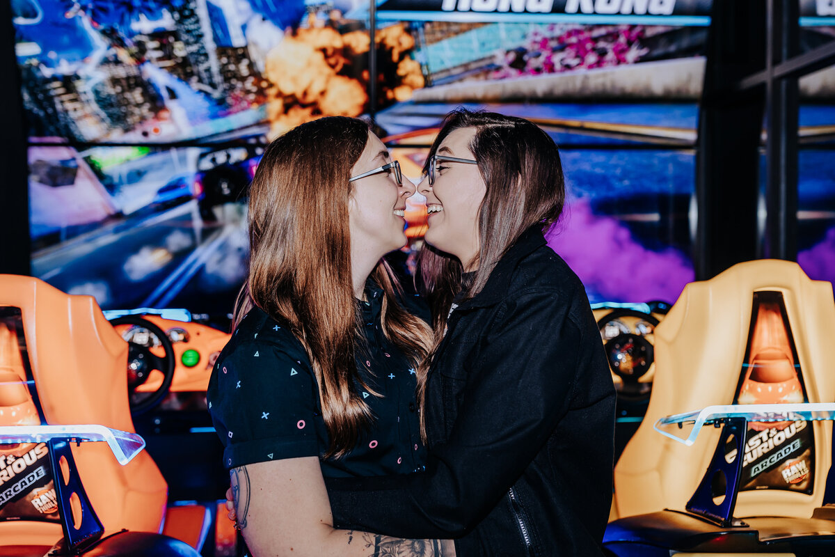 Nashville engagement photographer captures newly engaged couple kissing at arcade during Nashville engagement photos