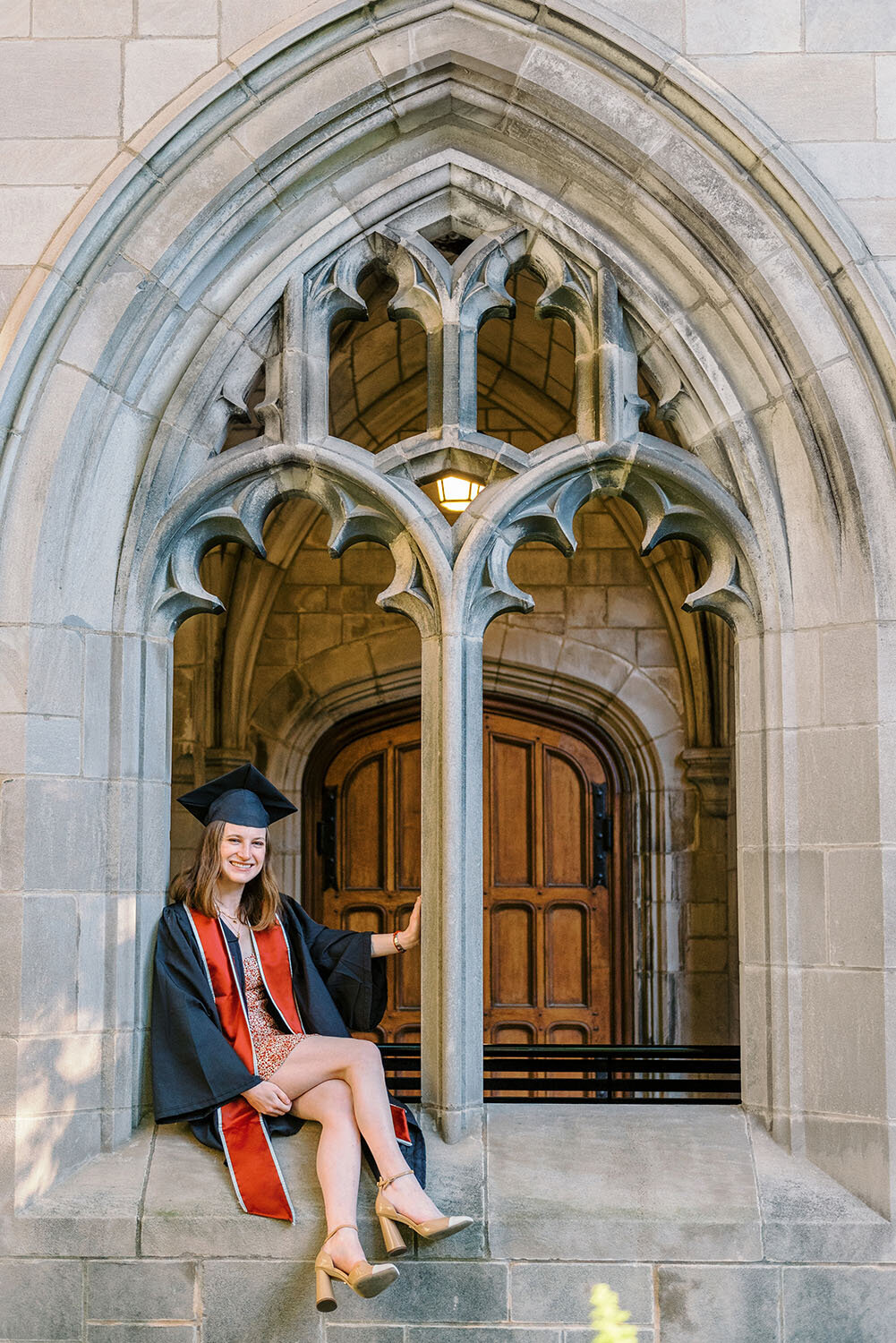 UChicago graduate sitting in the window at Bond Chapel