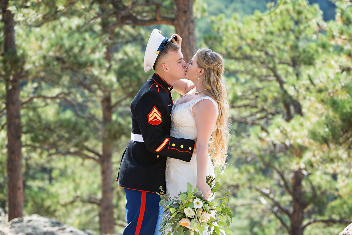 bride pushes her military groom's hat back to kiss him