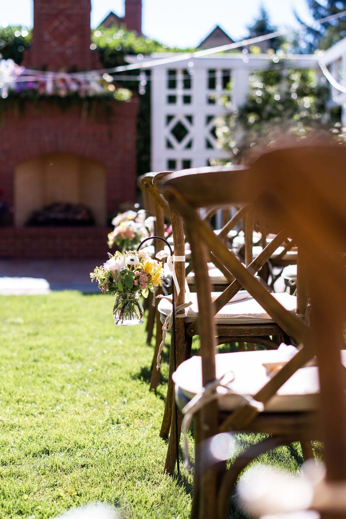 Wedding ceremony flowers on chairs along the aisle.