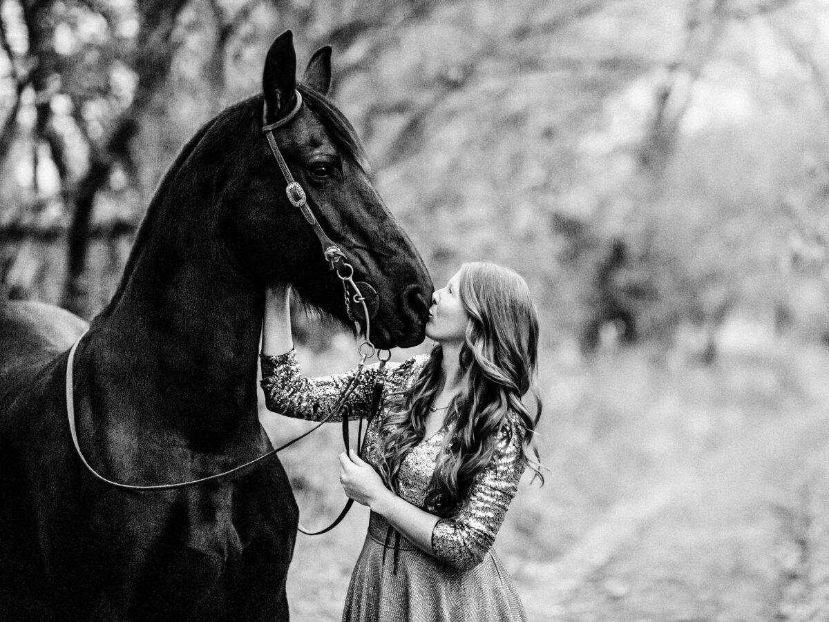 woman kissing horse on the nose