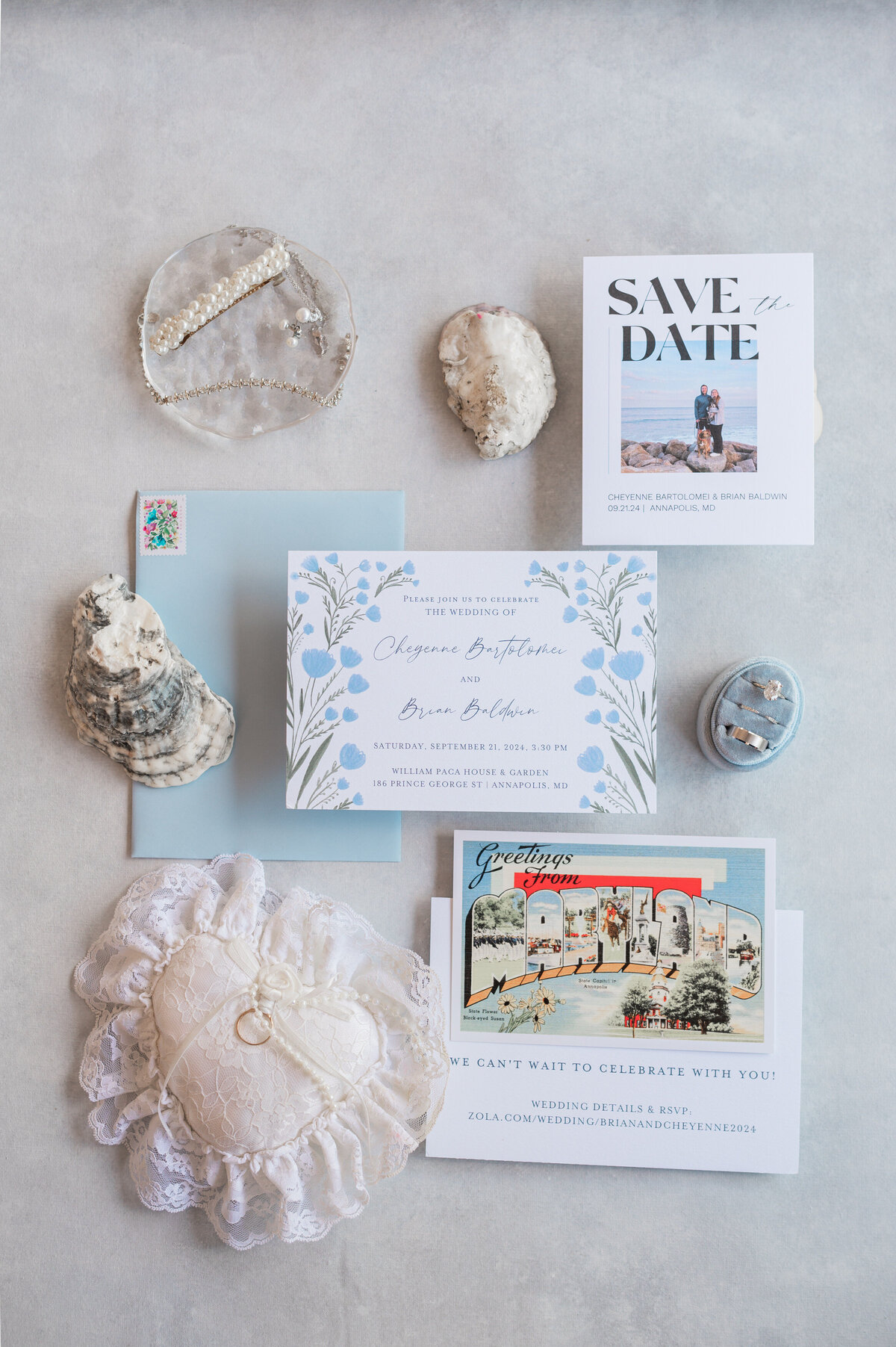 Wedding invitations, jewelry, and shells laid out next to each other