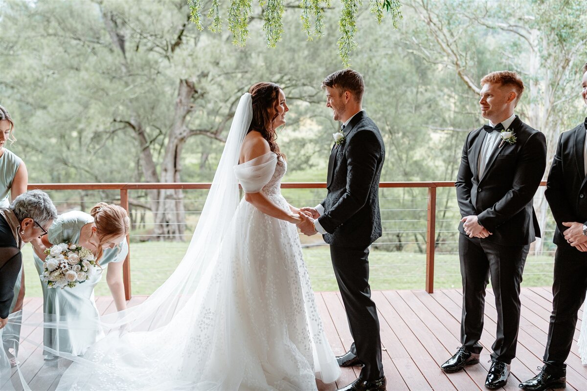 The bride, adorned in ivory lace, exchanges vows with her groom under a canopy of blossoming cherry trees.
