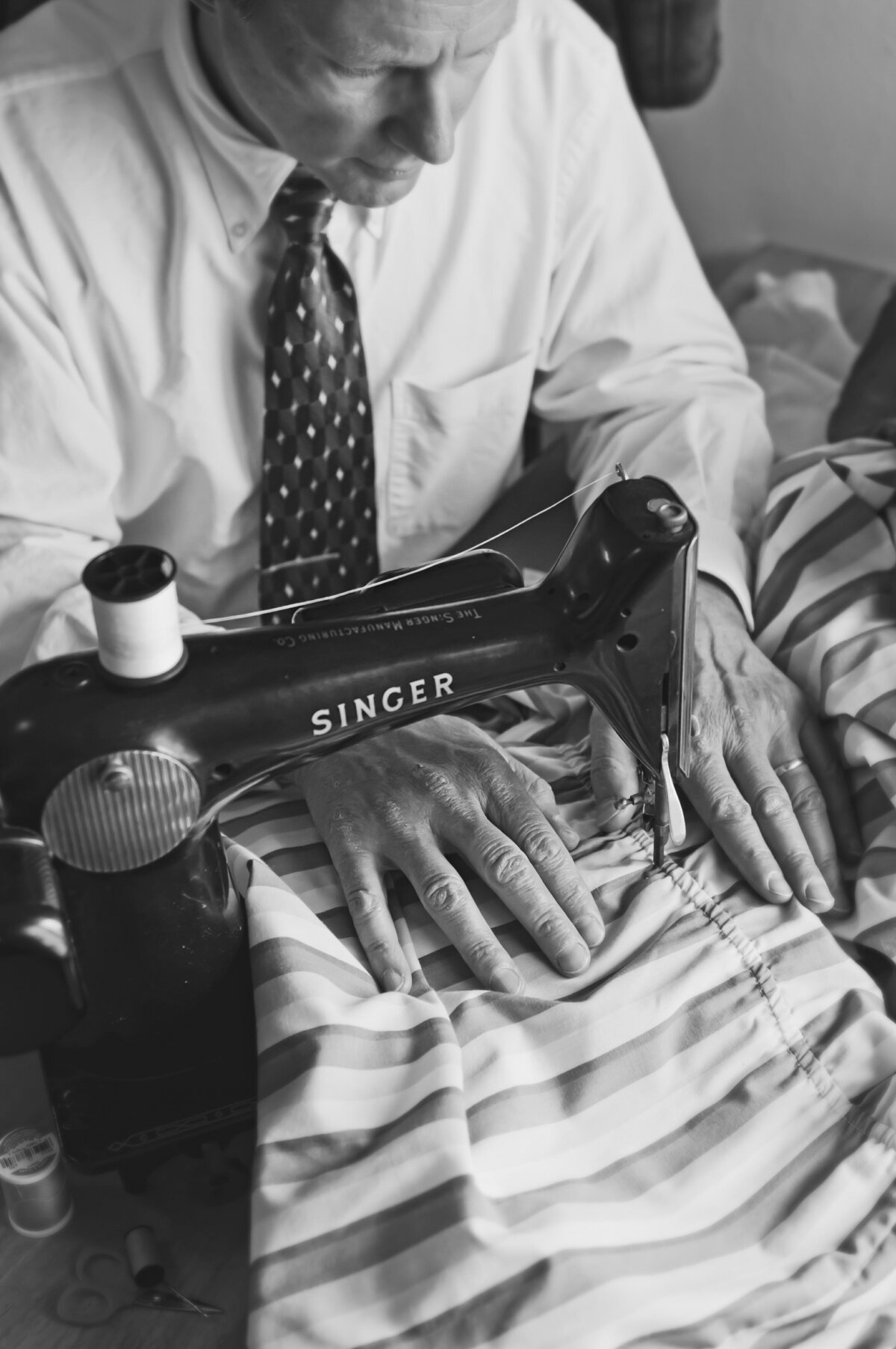 A black and white photo of a person sewing