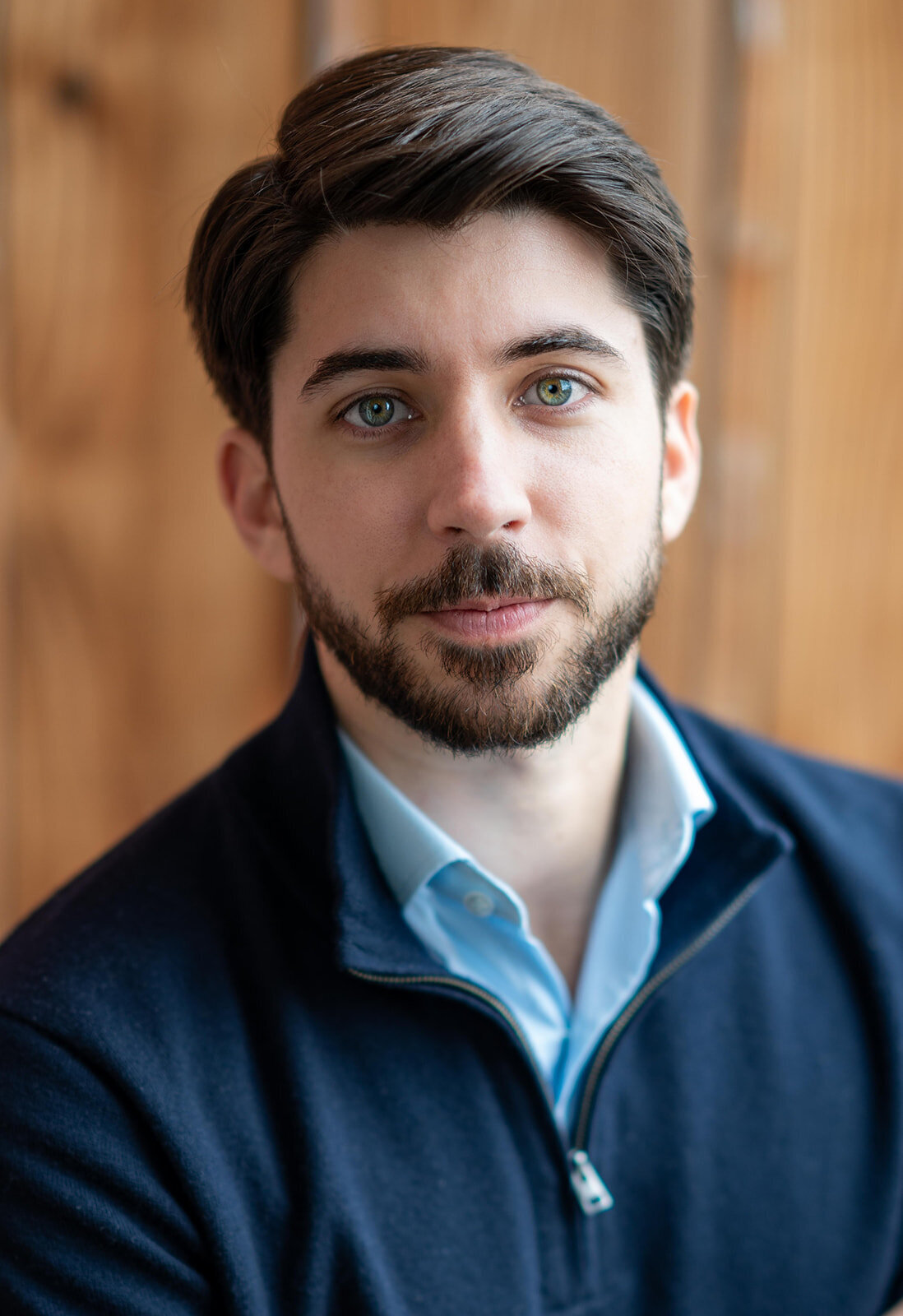 Close-up image of a bearded man looking serious while wearing a dark sweater