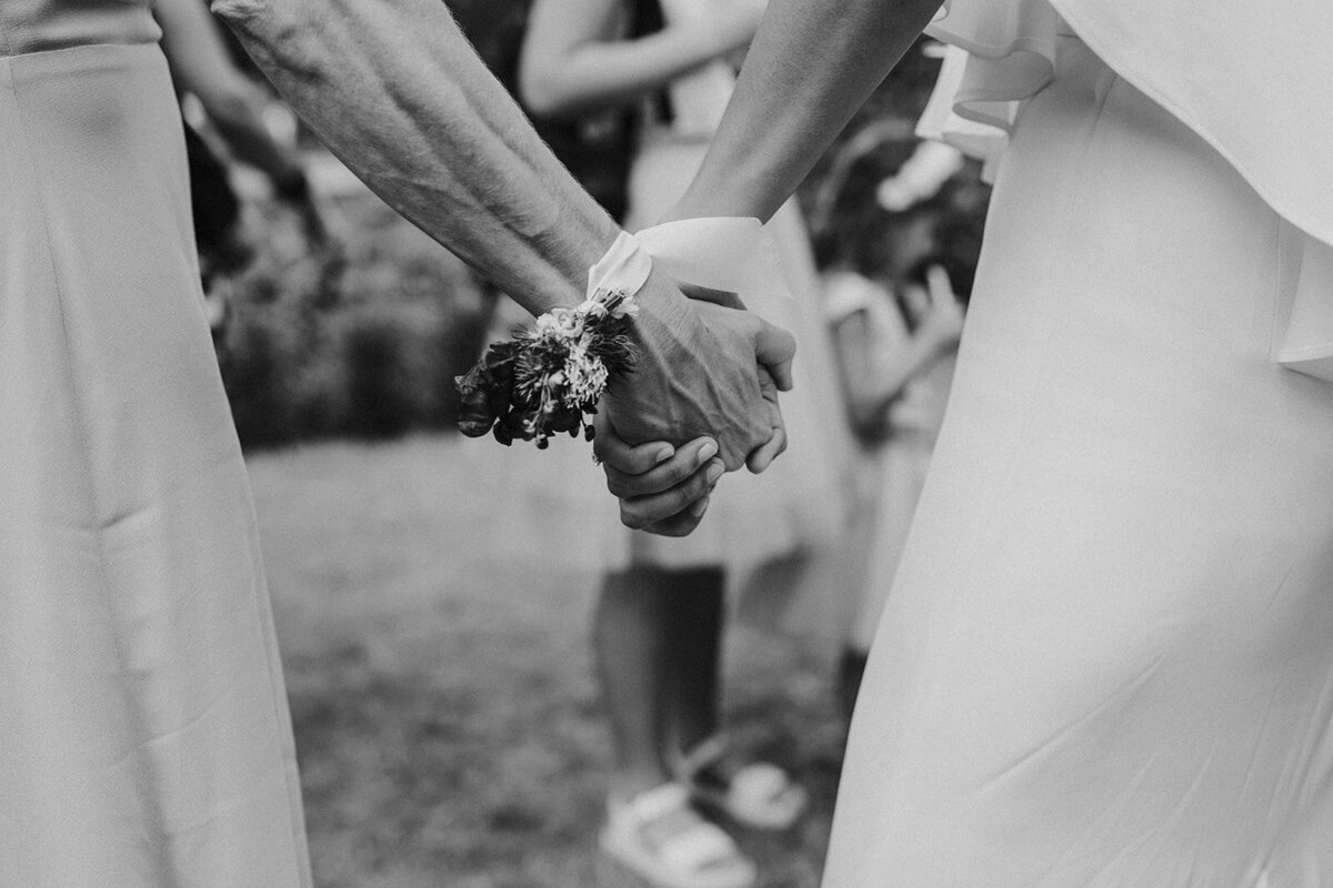 bruid houdt hand bruidsmeisje vast