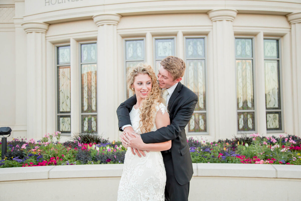 a groom hugging a bride from behind