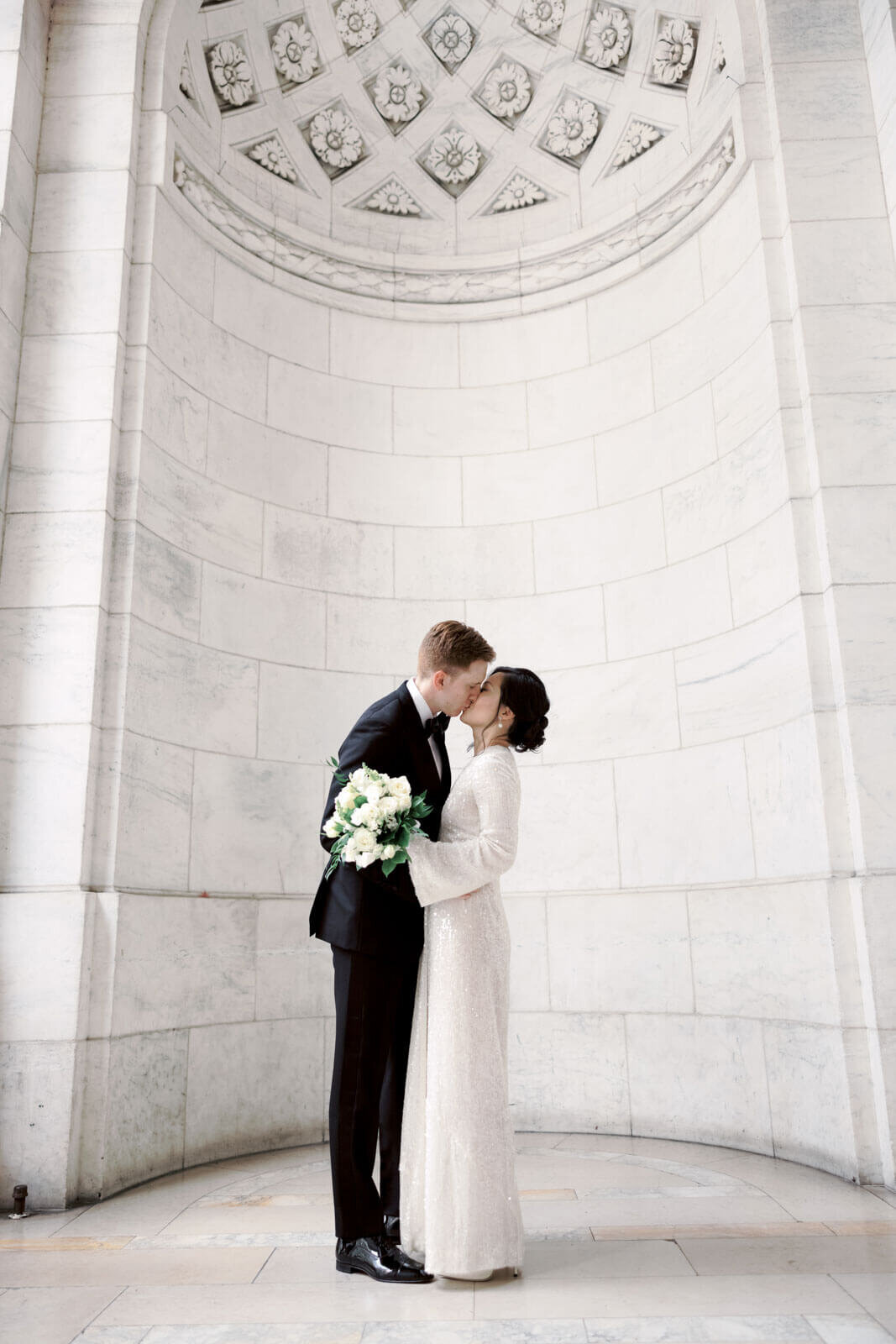 The bride and the groom are kissing in the New York Public Library, NYC. Image by Jenny Fu Studio