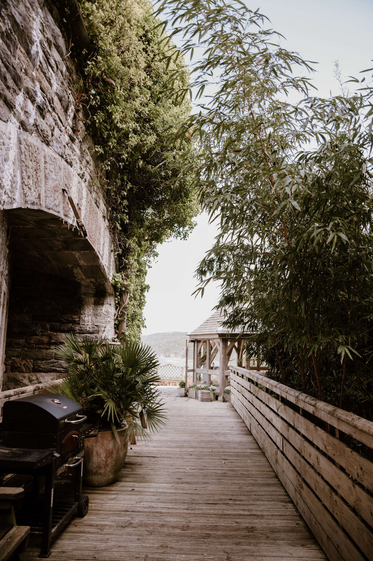 The side view of the fort with a bbq and the gazebo at the end of the path