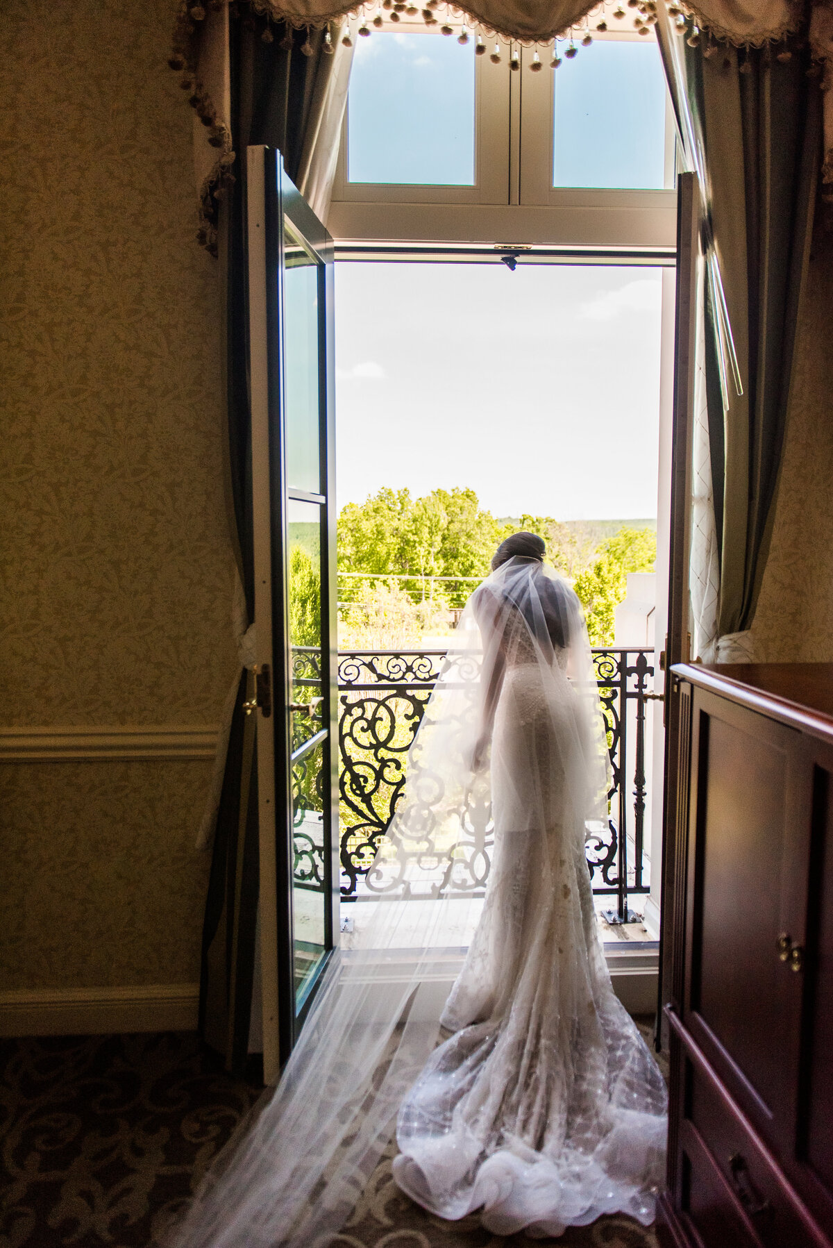 wedding photo of bride leaning over balcony at nemacolin resort