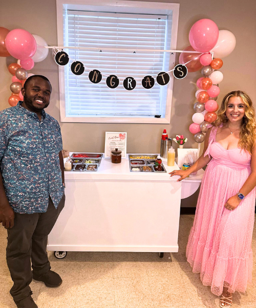 Dessert cart setup with couple and party banner