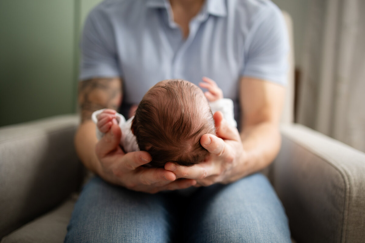 Baby's head in dad's hands