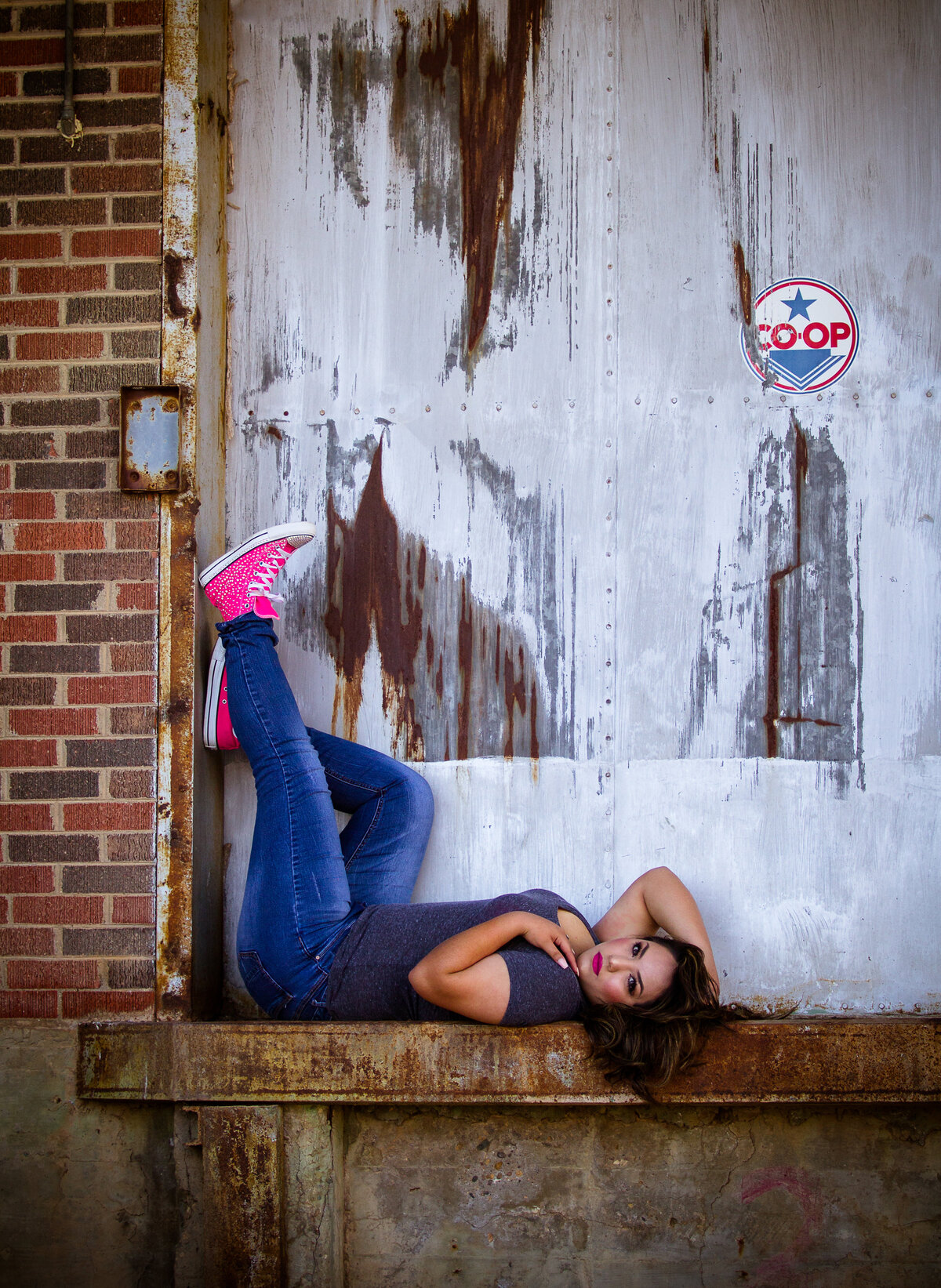 Senior girl laying down with legs up in downtown Plainview tx
