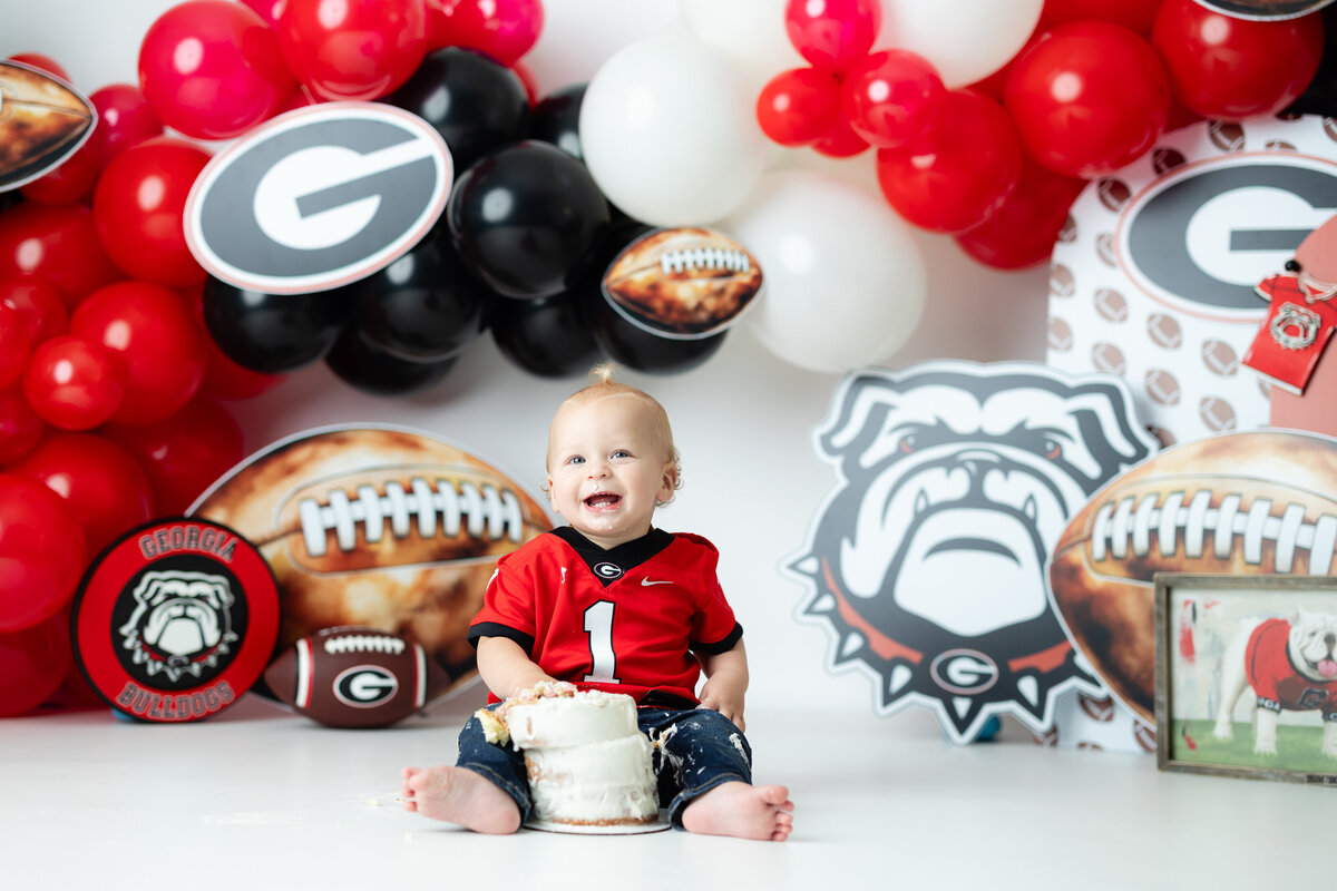 Baby boy in Georgia Bulldogs jersey during UGA football cake smash photography session in Canton GA