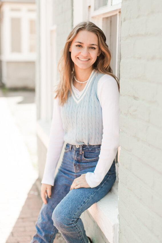 senior girl sitting in window sill