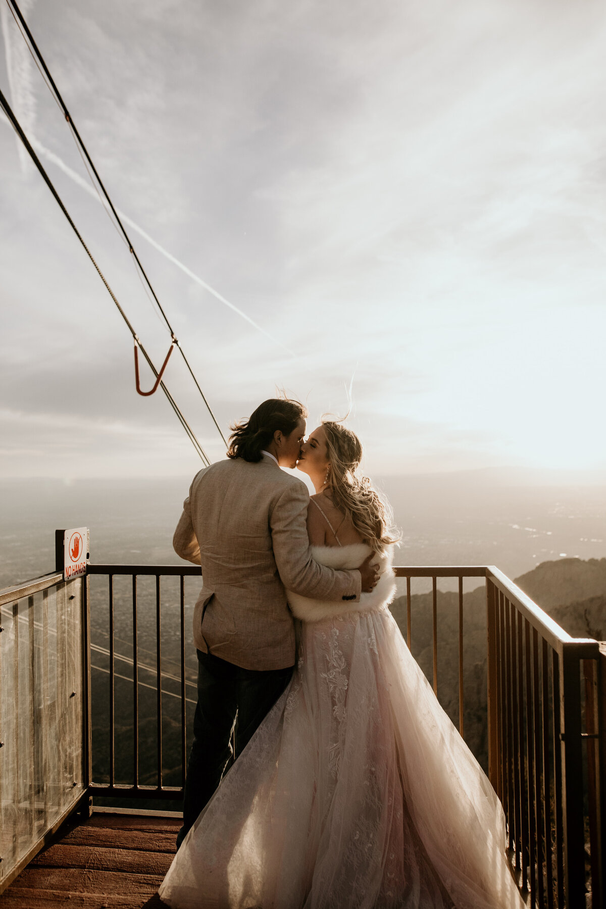 bride and groom on top of Sandia Peak Tramway looking down at Albuquerque