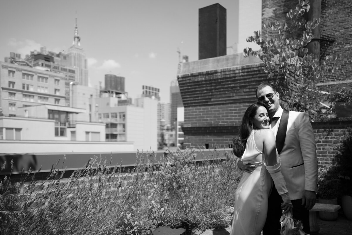 Black and white portrait of Japna and Chris embracing on a New York City rooftop during their elopement.