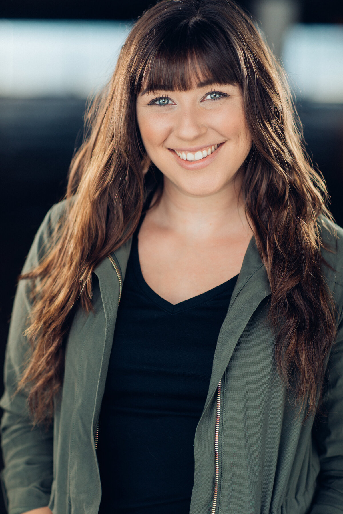 Headshot Photograph Of Young Woman In Outer Gray Jacket And Inner Black V-Neck Shirt Los Angeles
