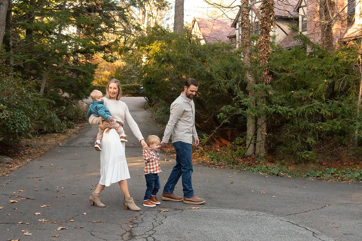 A family holds hands and walk in front of the estate at Whip Hill Park in Stoneham.