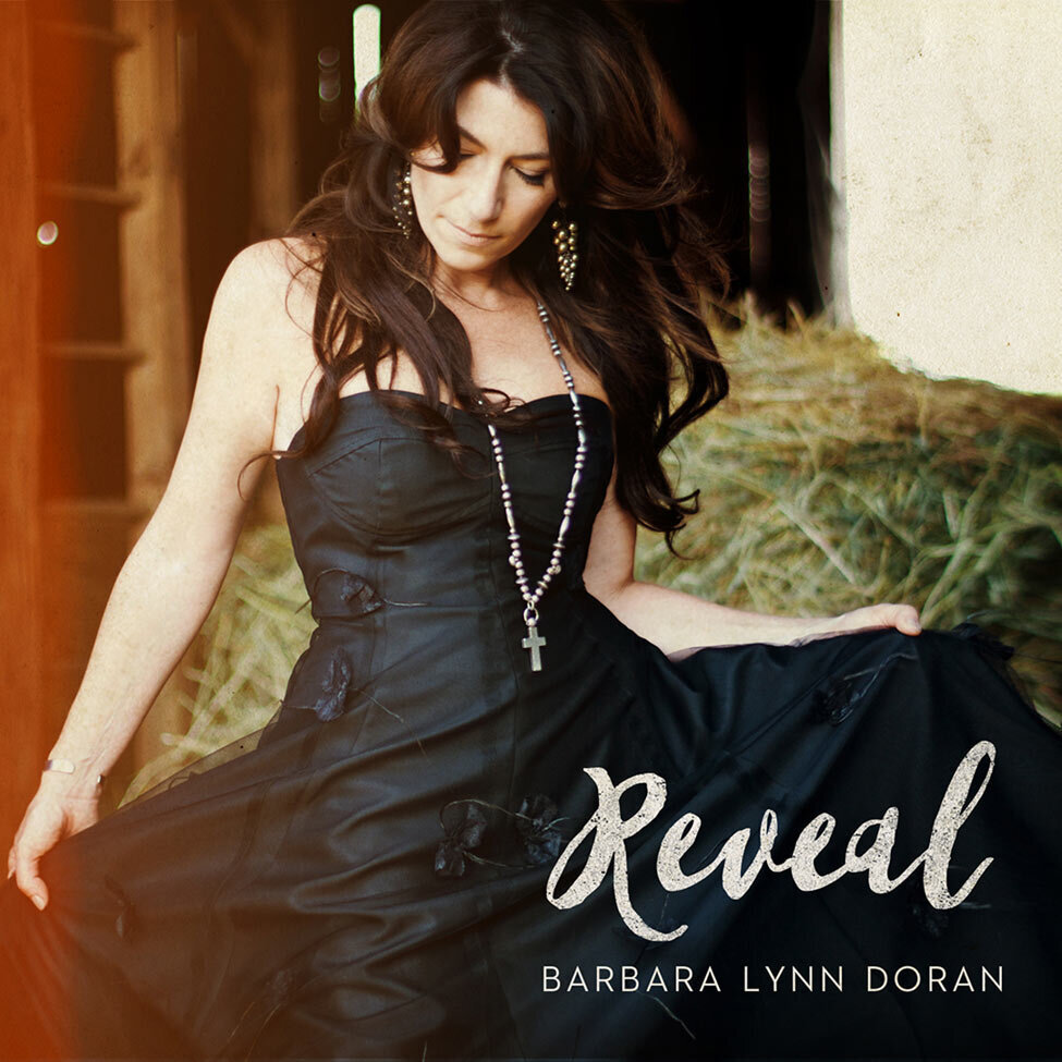 Country Music Single Cover Title Reveal Artist Barbara Lynn Doran wearing black evening gown in barn hale bale behind her