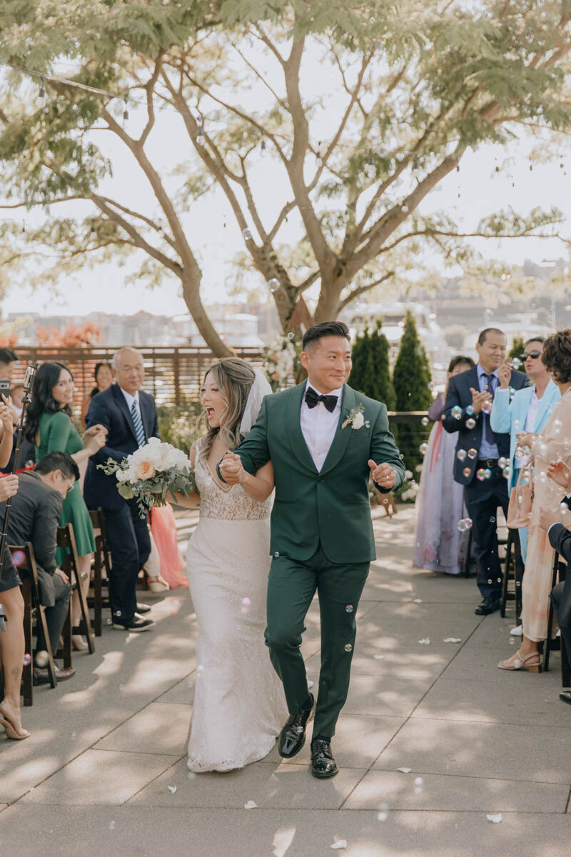 Couple holding hands and celebrating while walking down the aisle