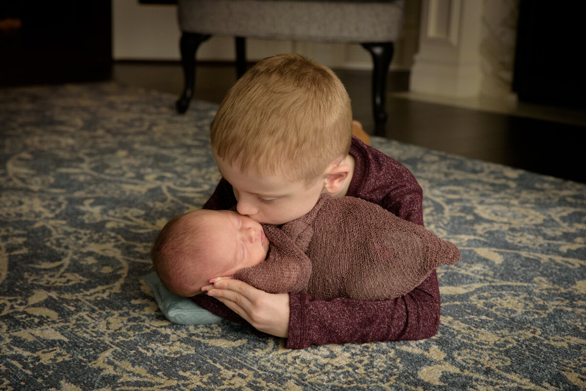 Big brother holding brand new baby sister in their home in Green Bay, Wisconsin.