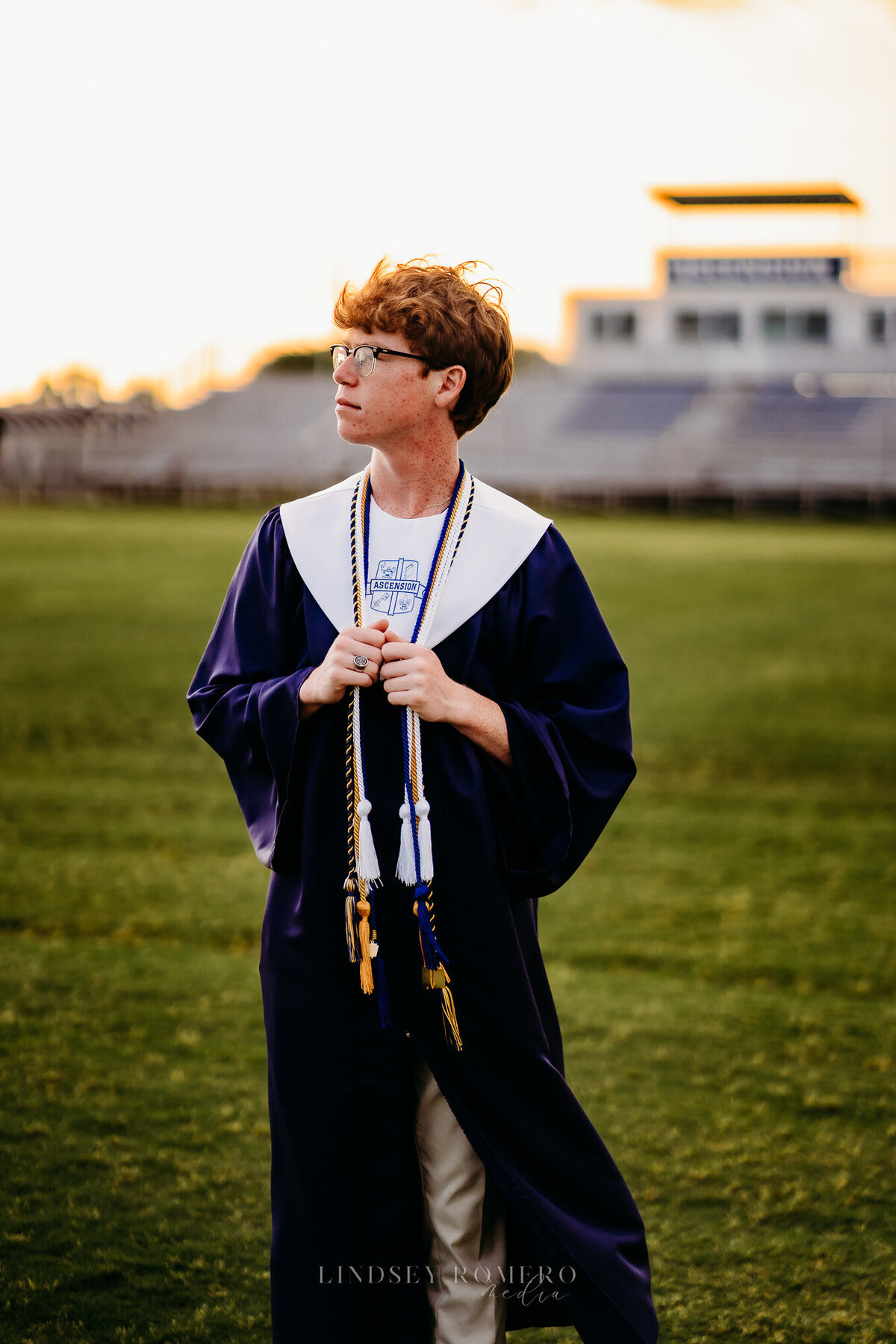 guy graduating senior pose on football field in Youngsville, la