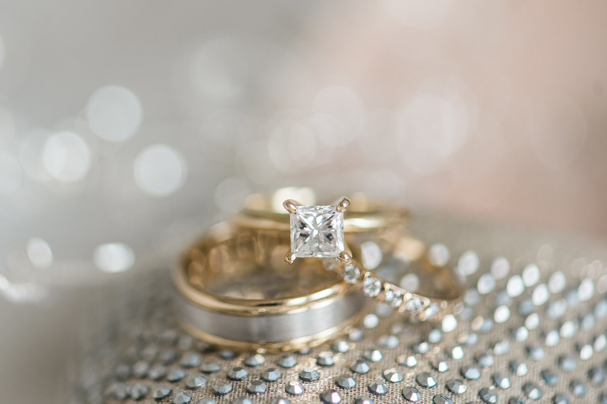 Stunning engagement ring resting on  a silver and gold wedding band.