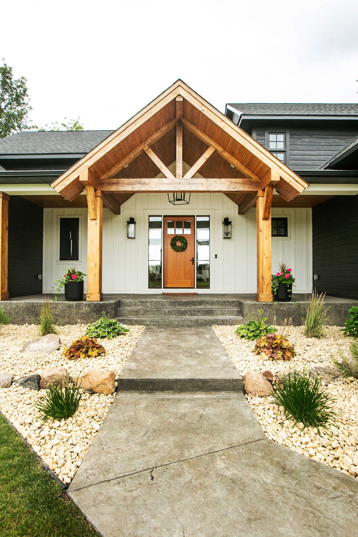 Exterior view of custom home in Otsego, Minnesota with modern wood details and front porch built by Cornerstone Custom Builds