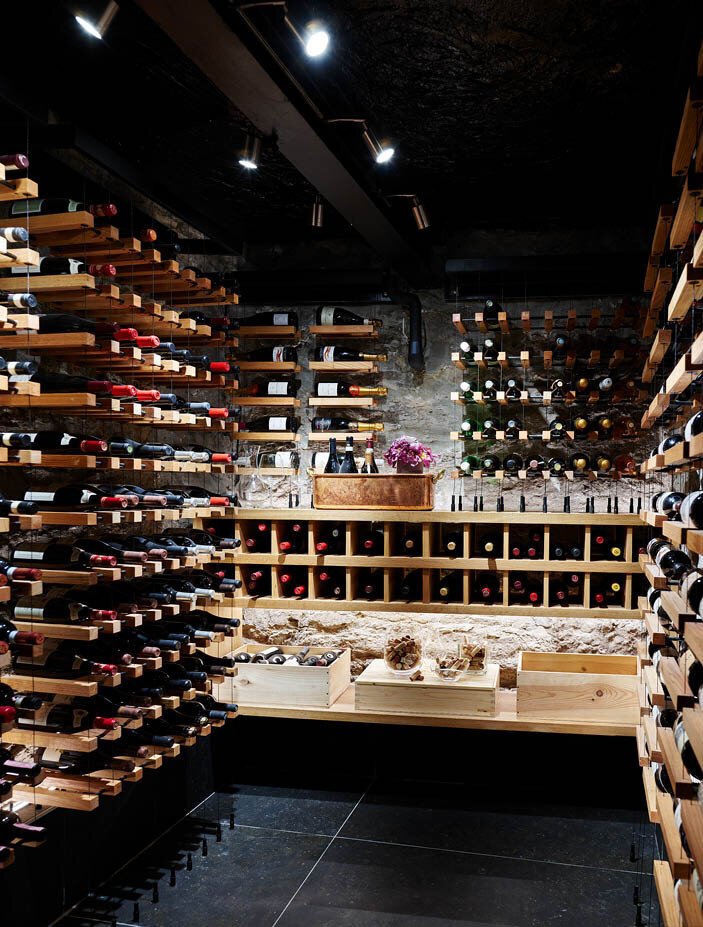 A former coal room with original walls, now a modern wine room with new tile flooring and air control for perfect wine storage. By Sarah Scales.