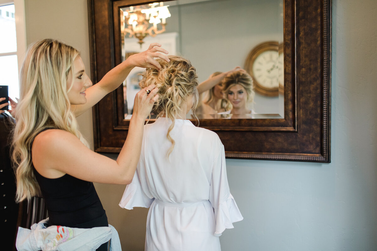 woman pinning up a bride's hair