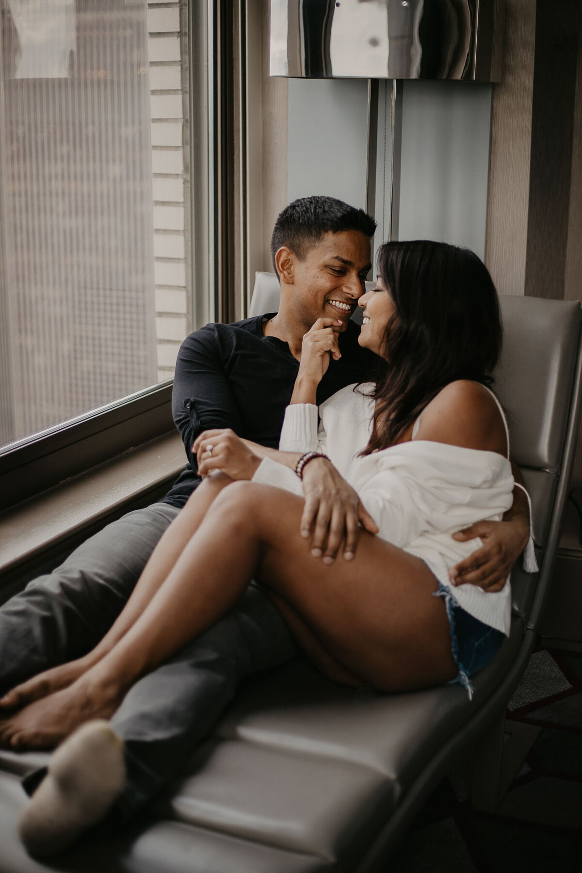 Couple lounging in a chair by the window