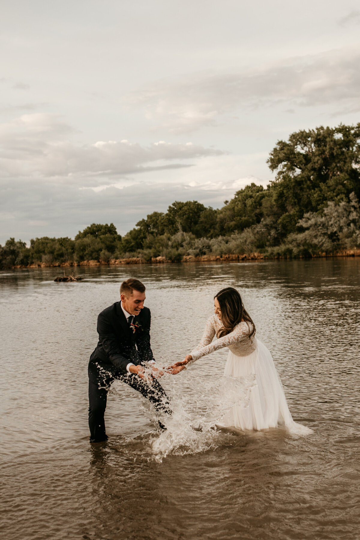 Newlyweds splashing and playing in river