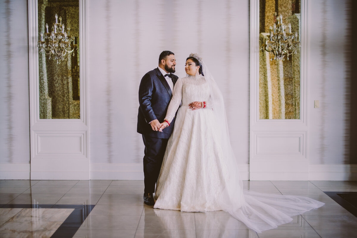 indian sikh bride and groom in white dress share moment during wedding reception at the lake terrace in lakewood nj