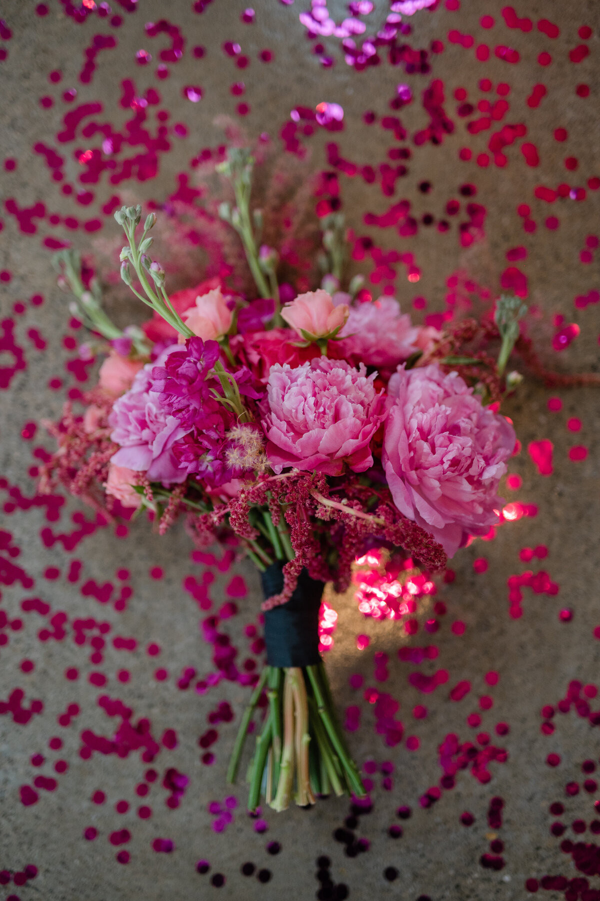 Pink wedding bouquet with pink confetti on ground