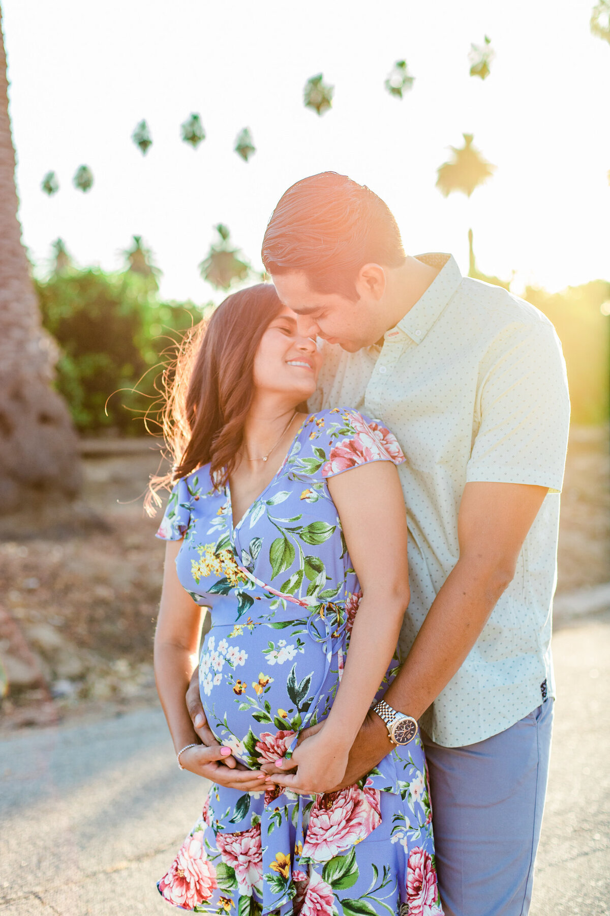 dad kisses mom holding her belly