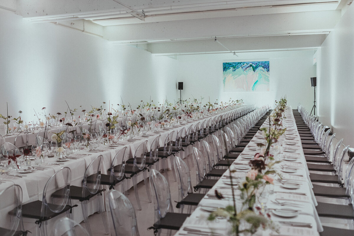 Rows of airy floral vases compliment the modern decor of an art gallery wedding reception in Montreal.