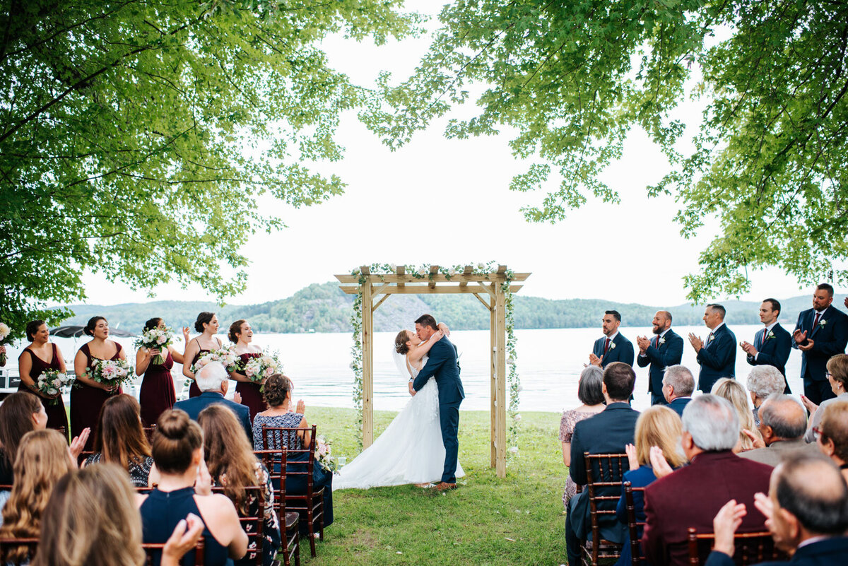 bride and groom have first kiss at wedding reception at lake bomoseen lodge summer vermont wedding