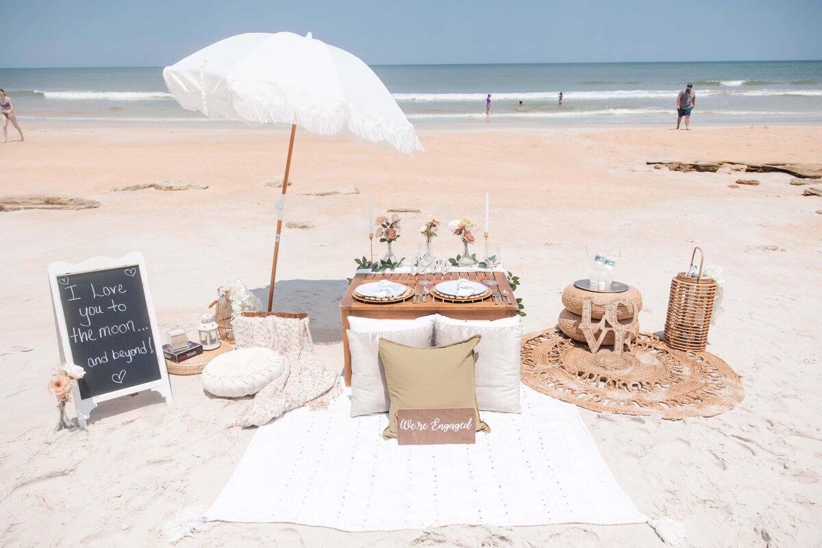 A beach proposal on St Augustine Beach with a picnic set up | Photo by Phavy Photography