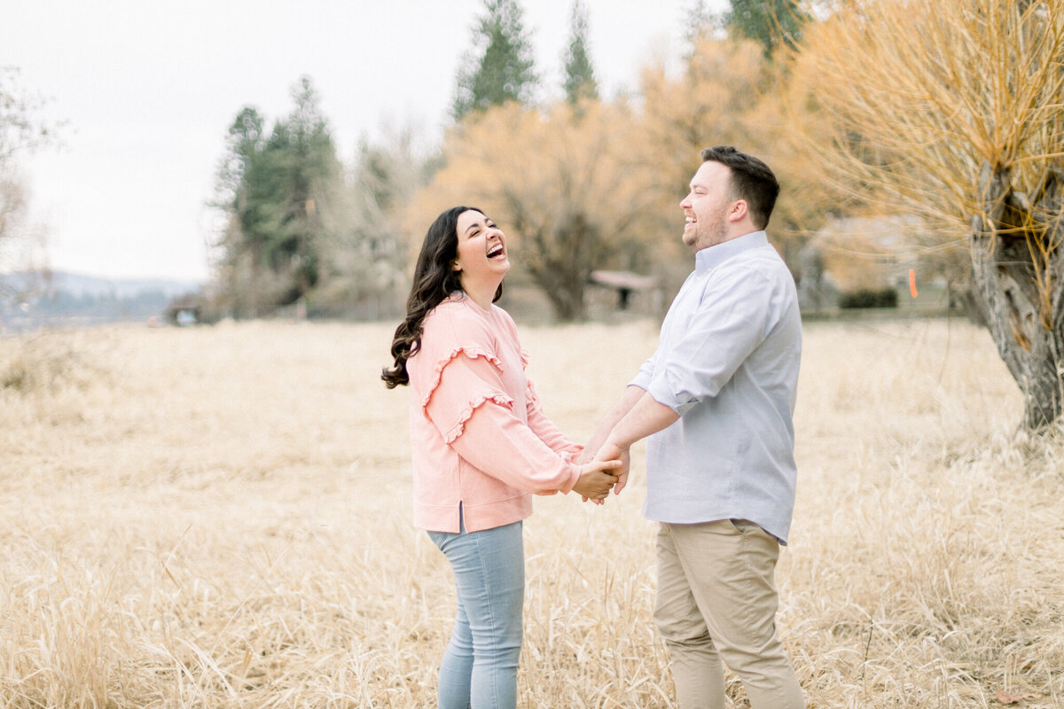 couple holding hands and laughing  celebrating their engagement taken by seattle wedding photographer