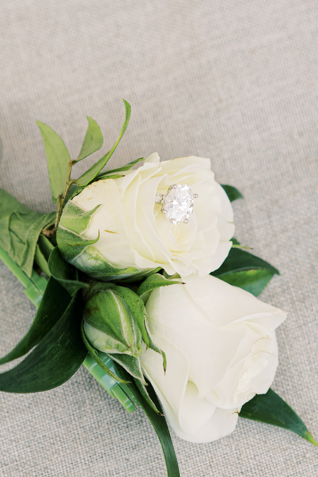 a wedding ring resting on white roses